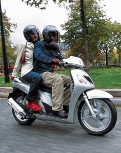 Conducente e passeggero in coppia su uno scooter